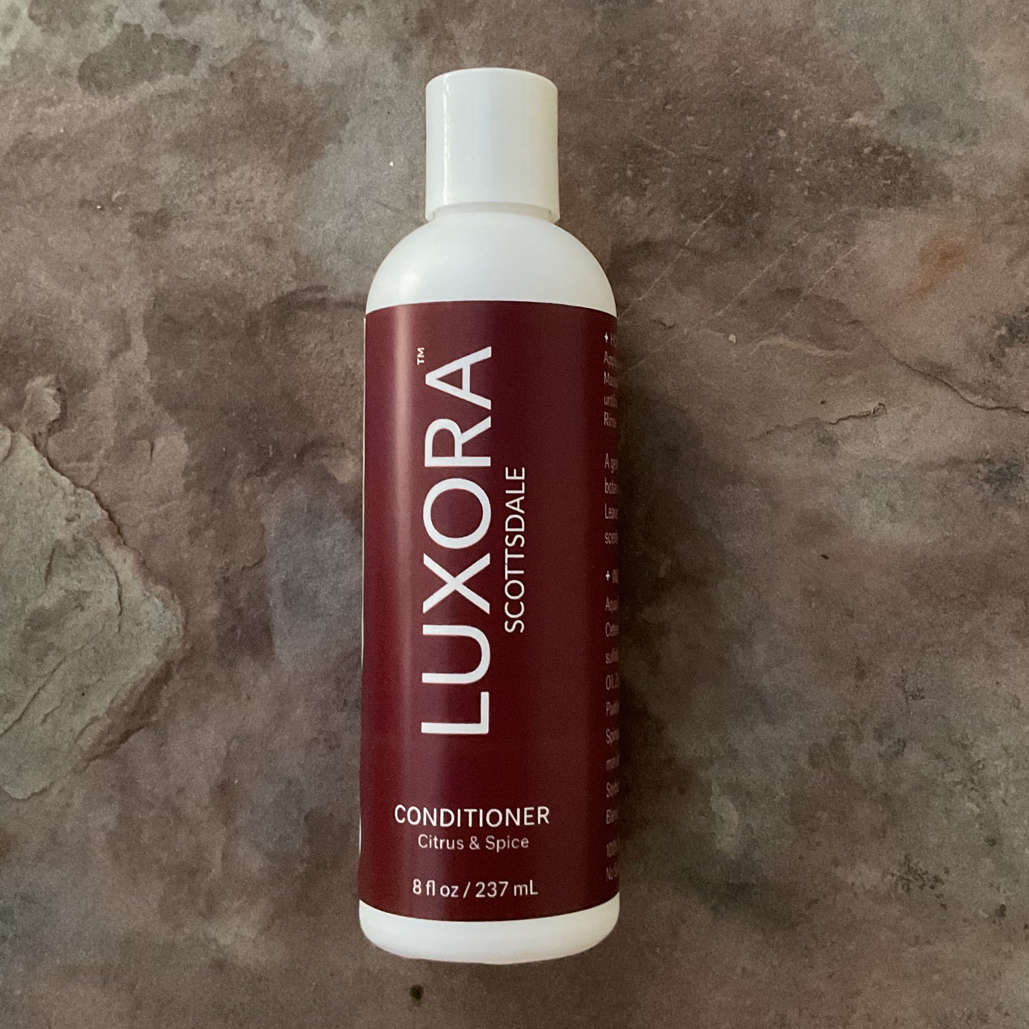 White hair conditioner bottle with a red Luxora Scottsdale label on white bottle, Citrus & Spice scent and size is 8 fl oz / 237 mL size