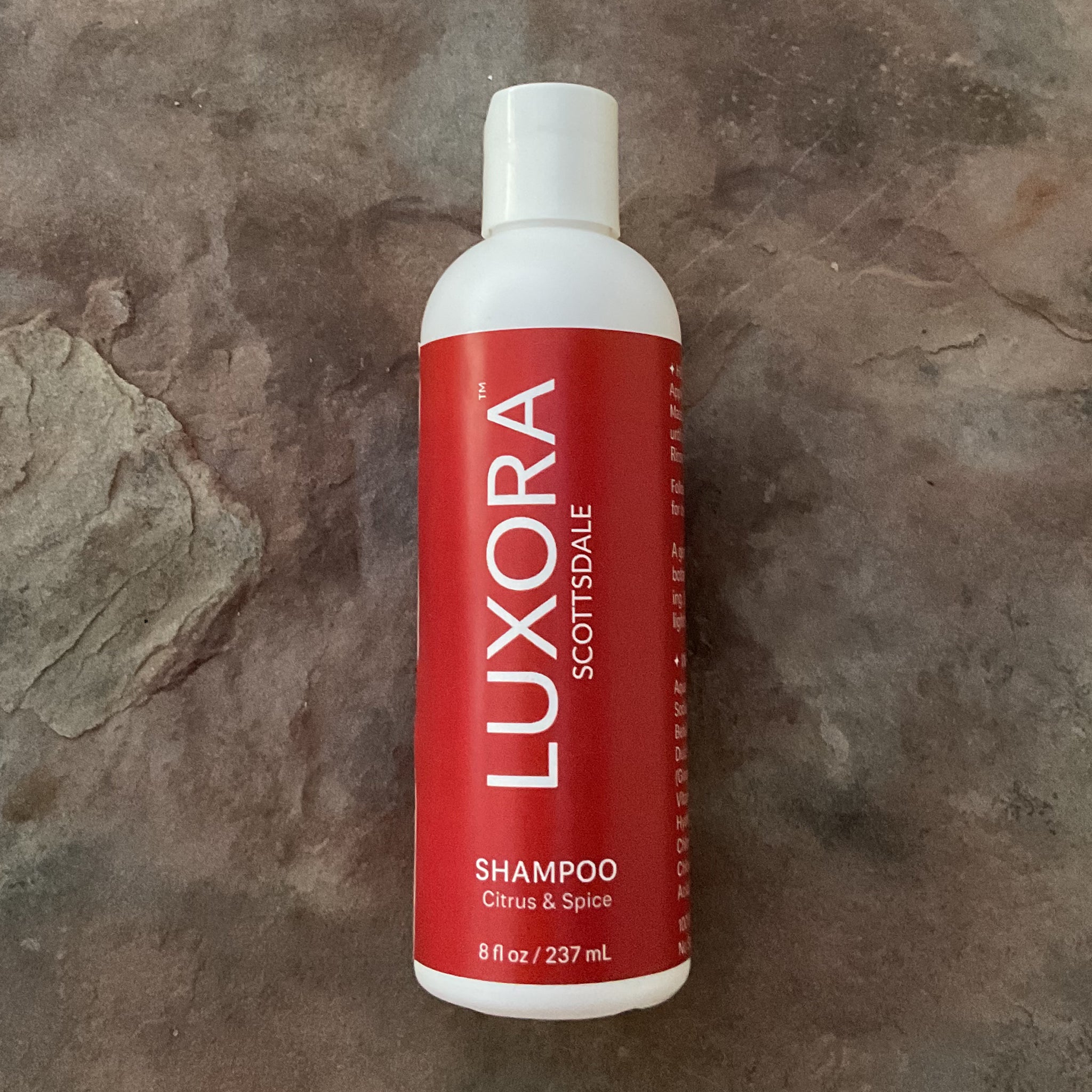 White shampoo bottle with a red Luxora Scottsdale label on white plastic bottle, Citrus & Spice scent in 8 fl oz / 237 mL size